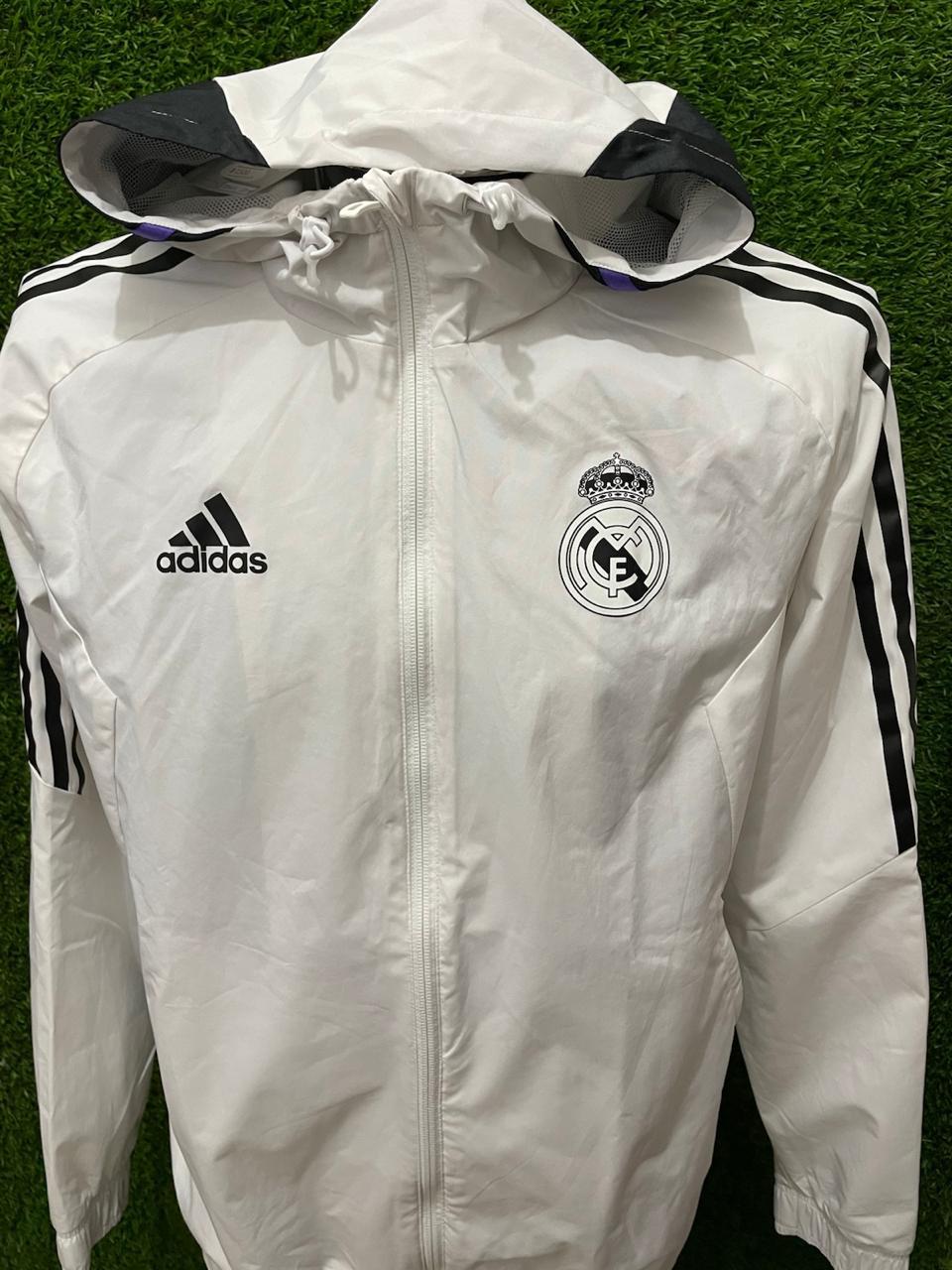 ROMPEVIENTOS REAL MADRID CON GORRO 2022