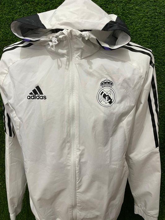 ROMPEVIENTOS REAL MADRID CON GORRO 2022