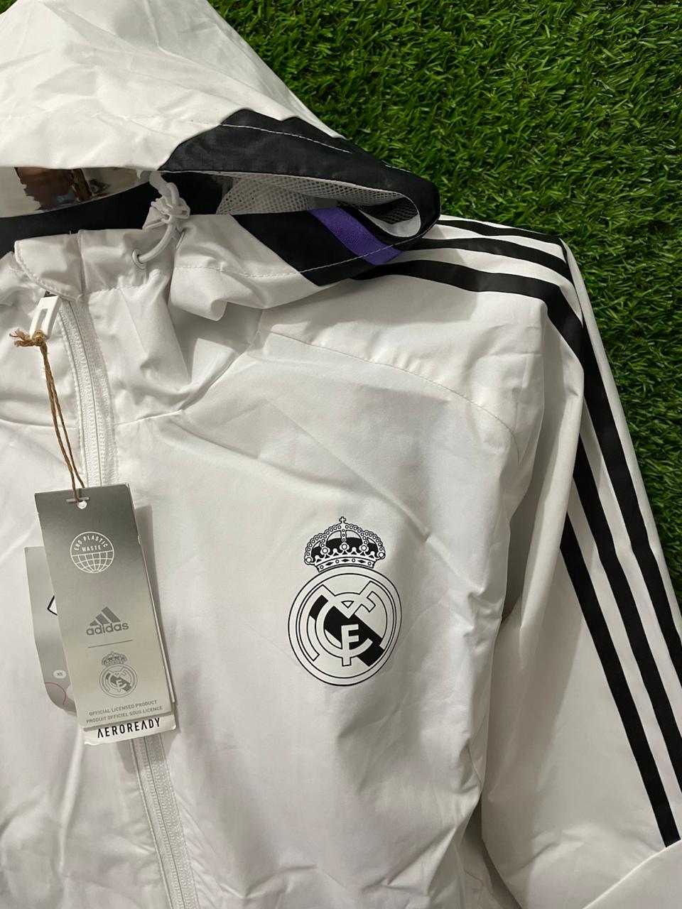 ROMPEVIENTOS REAL MADRID CON GORRO 2022